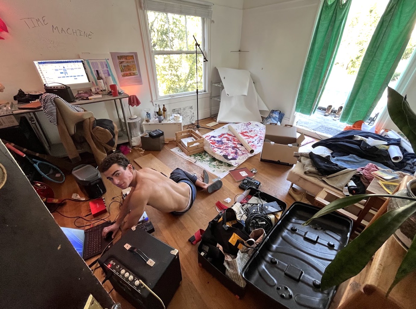 A room mid-build with TIME MACHINE written on the wall, cables and painted paper across the floor